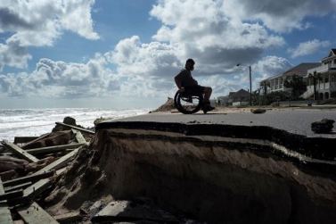 Una persona con disabilità in carrozzina lungo una parte di un’autostrada distrurtta dall’Uragano Matthew a Flagler Beach, in Florida, il 9 ottobre 2016 (© Jewel Samad/AFP/Getty Images) diritto al salvataggio